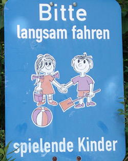 Schild: Bitte langsam fahren – spielende Kinder